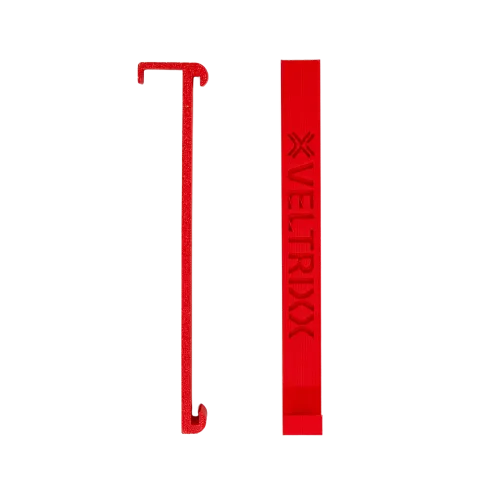 Rood plastic voorwerp met een lange haak links en een rechthoekige staaf met de tekst "VELTRIXX" erop, tegen een witte achtergrond.