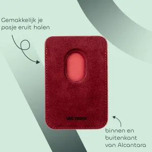 Rood kaarthoesje van Alcantara met opening voor makkelijk uitnemen van pasjes. Achtergrond in groene tinten. Tekst benadrukt materiaal en gebruiksgemak.