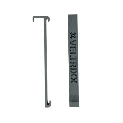 Twee grijze plastic onderdelen, waarvan één met de tekst "VELTRIXX" erop gegraveerd.