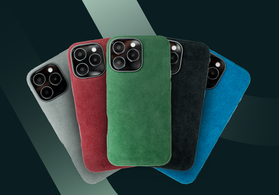 Vijf smartphones met gekleurde suède hoesjes in grijs, rood, groen, zwart en blauw, tegen een donker achtergrond.